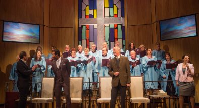 Pastor Paul (Anthony Fusco*, left) begins a church service with Associate Pastor Joshua (Lance Gardner*), Elder Jay (Warren David Keith*) and his wife Elizabeth (Stephanie Prentice*) as the choir sings.