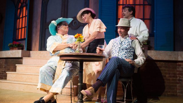 Georges (Ryan Drummond*) and Albin (John Treacy Egan*) dine at a cafe, served by Mme. Renaud (Adrienne Herro) and M. Renaud (Christopher Reber).