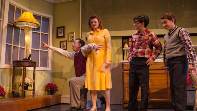 The Old Man (Ryan Drummond*) marvels at his new leg lamp, as Mother (Abby Haug*), Ralphie (Jonah Broscow*) and Randy (Jake Miller) look on.