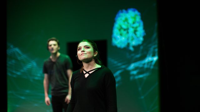 Katja (Emily Radosevich) admires her creation as Trent (Devin O'Brien, left) looks on.