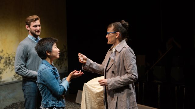 American couple Justin (Josh Schell*) and Sarah (Sango Tajima) receive the keys to Hitler's birthplace in Braunau after renting it from Gerta (Elissa Beth Stebbins).