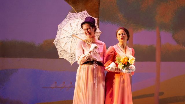 Celeste 1 (Amanda Farbstein) and Celeste 2 (Corrie Farbstein) observe passers-by on the Île de la Grande Jatte. Photo by Donny Gilliland.