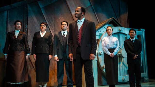 Bank Chairman (Anthony Rollins-Mullens*) and Ensemble.