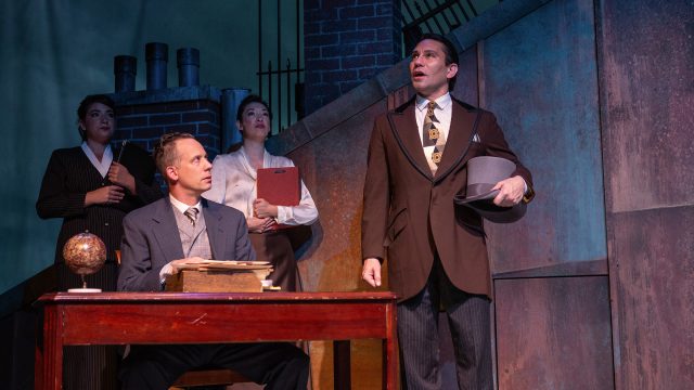 George Banks (Ryan Drummond*) and Von Hussler (Rudy Guerrero*) at the bank with the other clerks (Sophia LaPaglia and Kathryn Han*).