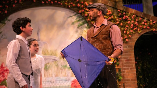 Michael (David Rukin) and Jane Banks (Ruth Keith) are taught to fly a kite by Bert (Wiley Naman Strasser).