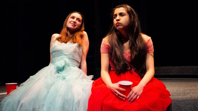 Blaze (Isabel Langen, left) and Rowena (Neiry Rojo) share a moment at their high school prom in Chelsea Marcantel's 'A White Girl's Guide to International Terrorism'.
