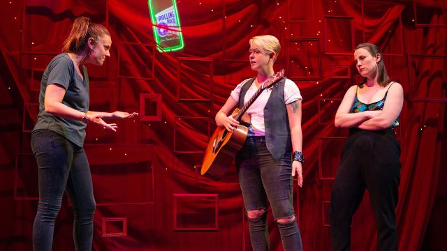 Spike (Em Lee Reaves, center) gets ready to perform as Gina (Katie Rubin) and Ani (Olivia Levine) look on.