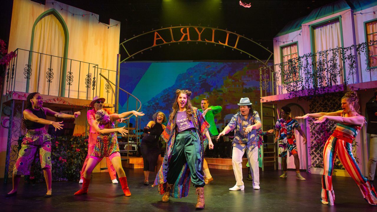 Feste (Sam Paley, center) opens 'Twelfth Night' with the people of Illyria (L-R: Tiana Paulding, Michael Gene Sullivan*, Amanda Le Nguyen, Cathleen Riddley*, Caleb Haven Draper, Tasi Alabastro, Jon-David Randle*, and Amanda Farbstein*).