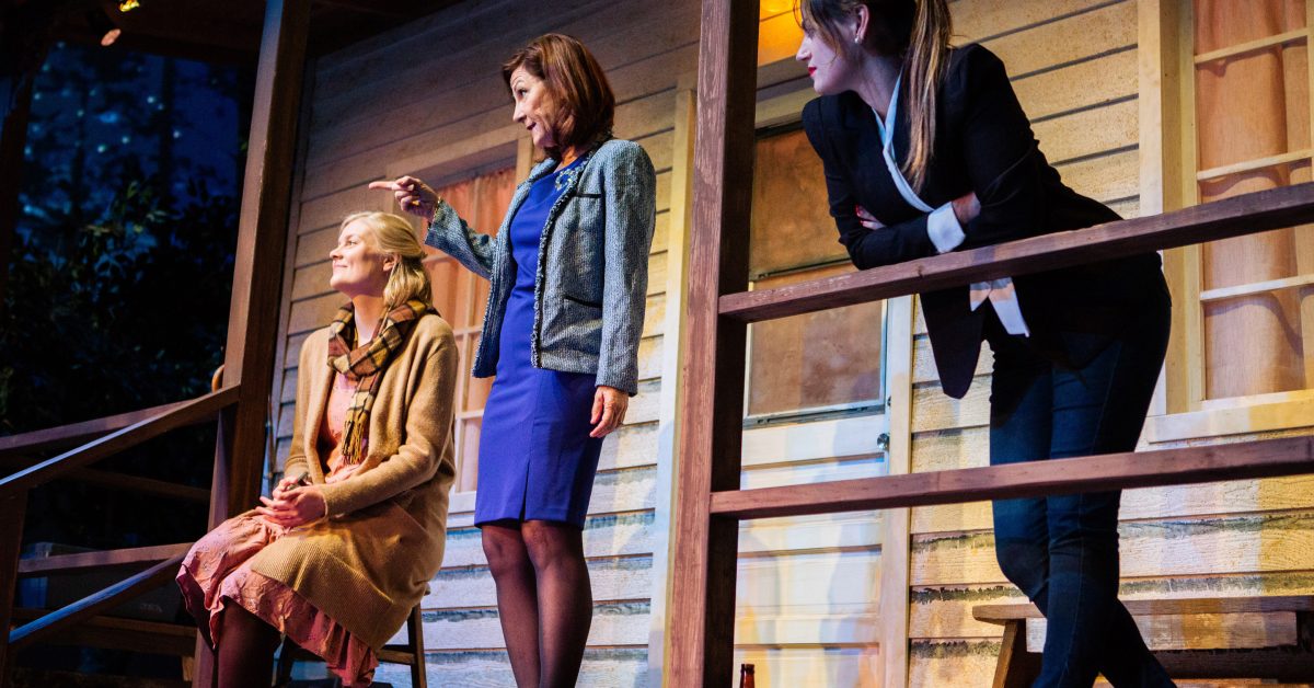 Gina (Susi Damilano*, center), newly inaugurated president of Transfiguration College, arrives at the party and greets Emily (Wera von Wulfen) and Teresa (Ash Malloy*) in 'Heroes of the Fourth Turning' at San Francisco Playhouse.