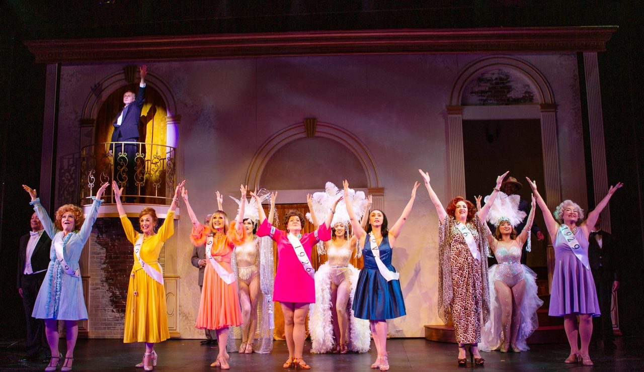 Singing 'Beautiful Girls' from the balcony, Roscoe (understudy Timothy Lynch) is accompanied by (front row, L-R) Hattie Walker (Lucinda Hitchcock Cone*), Phyllis Rogers Stone (Maureen McVerry*), Solange LaFitte (Jill Slyter), Stella Deems (Caroline Louise Altman*), Sally Durant Plummer (Natascia Diaz*), Carlotta Campion (Cindy Goldfield*), and Emily Whitman (Eiko Yamamoto) as they re-live their past as Follies performers and are joined by (back row, L-R) Dimitri Weismann (Louis Parnell), Benjamin Stone (Chris Vettel*), and the ghosts of Follies past (Emily Corbo, Ann Warque, and Catrina Manahan).