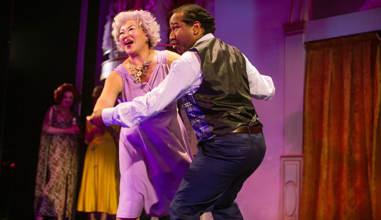 Emily (Eiko Yamamoto, center left) and Theodore Whitman’s (Rene Collins, center right) 'Rain on the Roof' catches the attention of guests Carlotta Campion (Cindy Goldfield*, background left) and Phyllis Rogers Stone (Maureen McVerry*, partially visible).