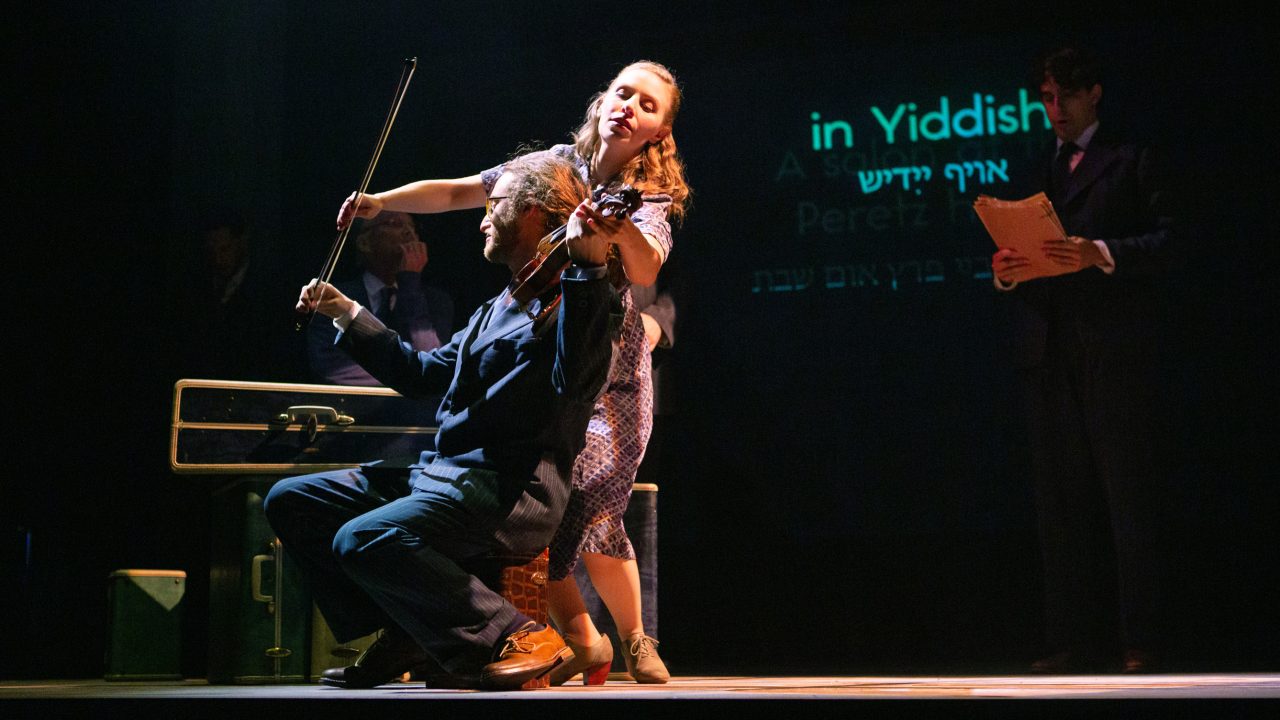 Halina (Rivka Borek*) takes the violin from Mayer Balsam (Matthew Stein, left). Production photography by Jessica Palopoli for 'Indecent' by Paula Vogel at San Francisco Playhouse.