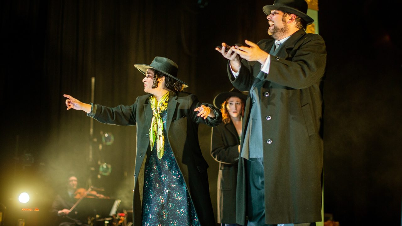 After the troupe made it through the grueling process at Ellis Island, they line up as Chassidim and sing, as they celebrate their entry into America (L-R): Vera (Rachel Botchan*), Chana (Malka Wallick*), and Mendel (Ted Zoldan). Production photography by Jessica Palopoli for 'Indecent' by Paula Vogel at San Francisco Playhouse.