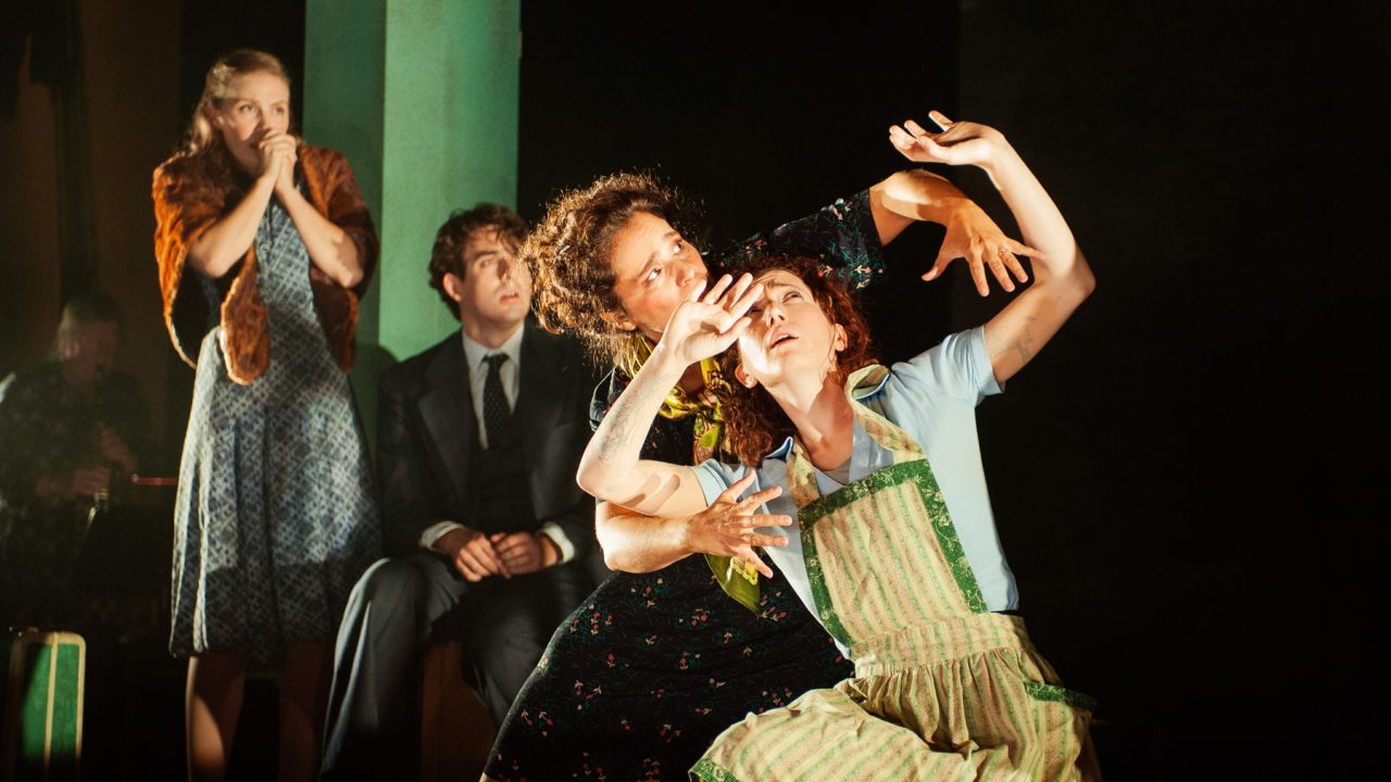 Vera (Rachel Botchan*, front left), playing Sarah, and Chana (Malka Wallick*, right), playing Rifkele, perform the last moments of 'The God of Vengeance' in Berlin, St. Petersburg, Constantinople, and Bratislava, as troupe members Halina (Rivka Borek*) and Avram (Billy Cohen*) watch from the wings. Production photography by Jessica Palopoli for 'Indecent' by Paula Vogel at San Francisco Playhouse.