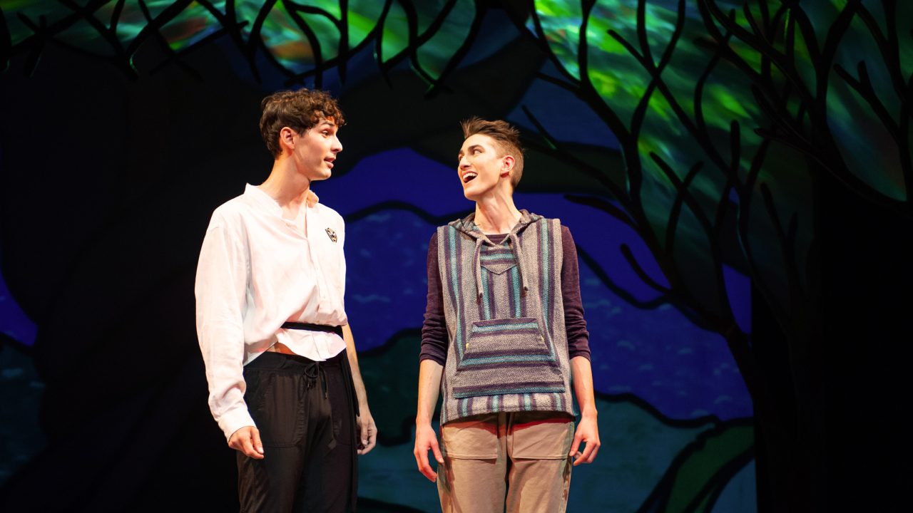 Orlando (Nikita Burshteyn) encounters Rosalind (River Navaille) in disguise as Ganymede in the forest of Arden in San Francisco Playhouse's musical version of "As You Like It," performing now through January 14, 2023.
