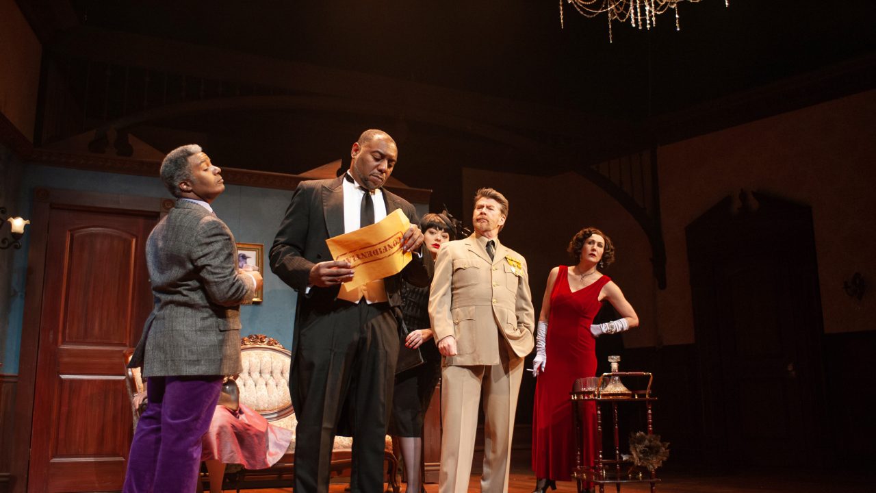 Wadsworth (Dorian Lockett), Mrs. White (Renee Rogoff), Colonel Mustard (Michael Ray Wisely), and Miss Scarlet (Courtney Walsh) examine a confidential envelope in San Francisco Playhouse's "Clue," performing March 9 - April 22.