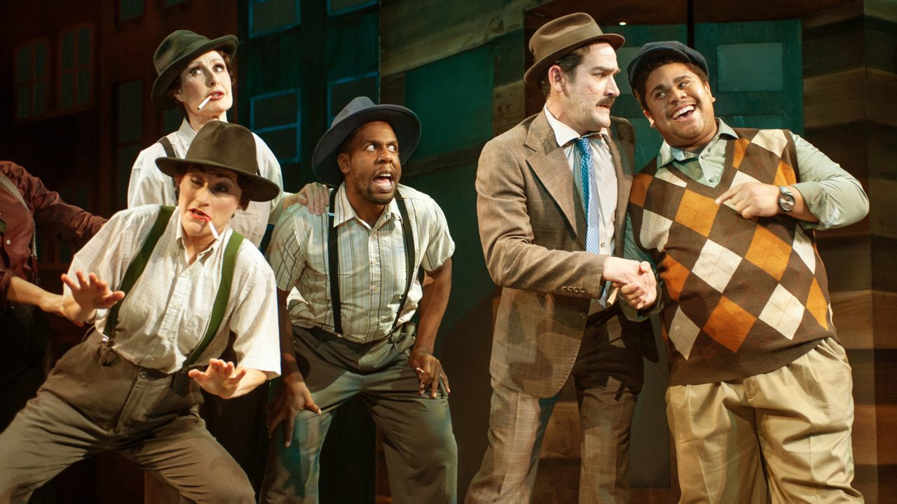 Gamblers (Alison Ewing, Jill Slyter, Jurä Davis) wonder where to get their fix as Nathan (Joel Roster) shakes hands with Harry (Miles Meckling) in San Francisco Playhouse's "Guys and Dolls," performing November 16, 2023 - January 13, 2024.