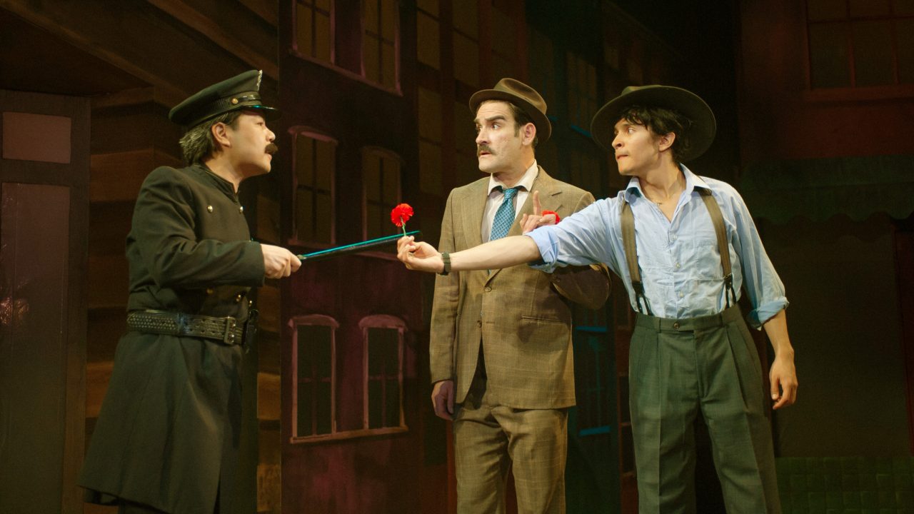 Lieutenant Brannigan (Alex Hsu) threatens Nathan (Joel Roster) and Benny (Chachi Delgado) in San Francisco Playhouse's "Guys and Dolls," performing November 16, 2023 - January 13, 2024.