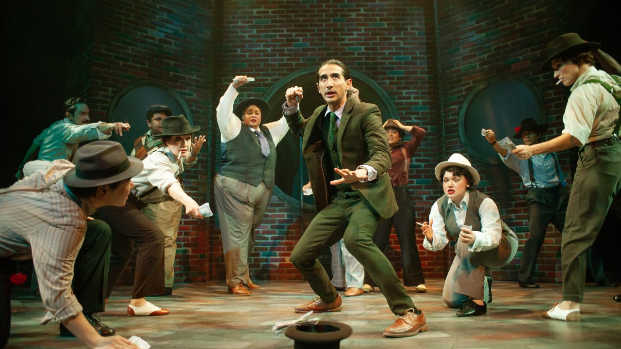 Sky Masterson (David Toshiro Crane - center) and gamblers roll the dice in San Francisco Playhouse's "Guys and Dolls," performing November 16, 2023 - January 13, 2024.