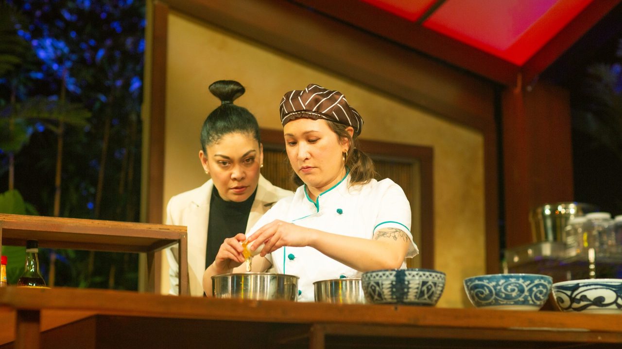 Consultant Vera (Rinabeth Apostol) learns about cooking from Mai (Jenny Nguyen Nelson) in San Francisco Playhouse's World Premiere Play "My Home on the Moon," performing January 25 - February 24.