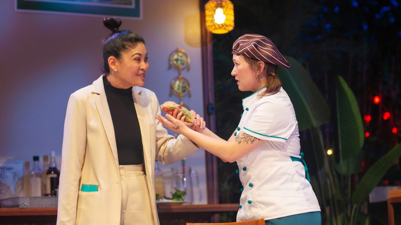 Vera (Rinabeth Apostol) is served by Mai (Jenny Nguyen Nelson) in San Francisco Playhouse's World Premiere Play "My Home on the Moon," performing January 25 - February 24.