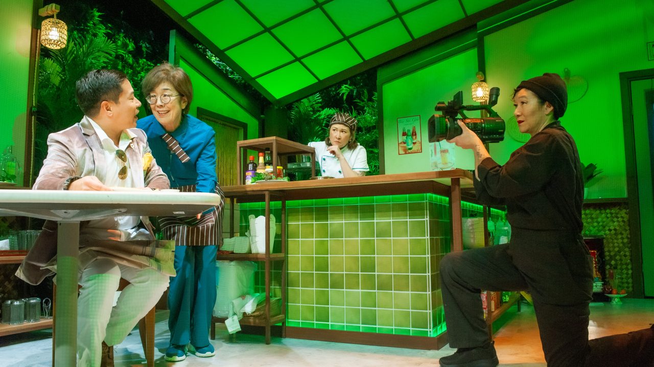 (L-R) A food critic (Will Dao) samples cuisine, watched by Lan (Sharon Omi), Mai (Jenny Nguyen Nelson) and a camera person (Erin Mei-Ling Stuart) in San Francisco Playhouse's World Premiere Play "My Home on the Moon," performing January 25 - February 24.