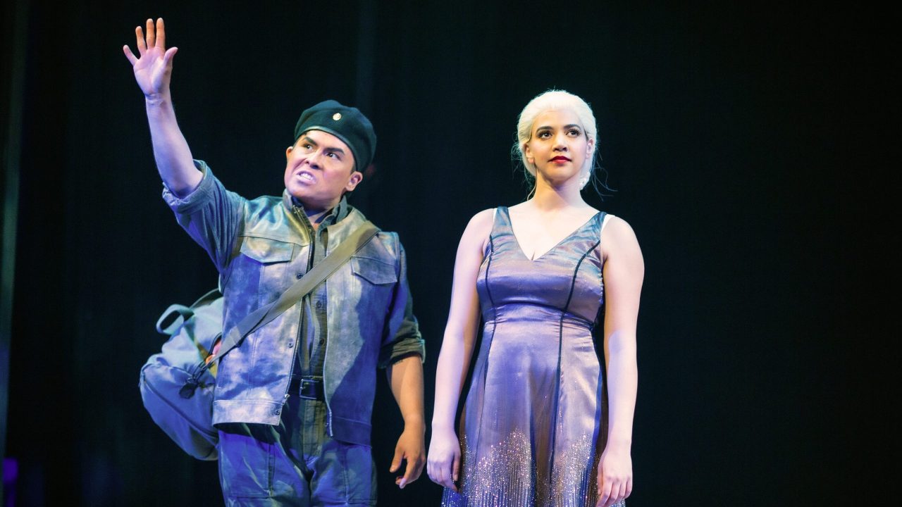 Che (Alex Rodriguez) comments on Eva Perón (Sophia Alawi) in San Francisco Playhouse's "Evita," performing June 27 - September 7, 2024. Che (Alex Rodriguez) comments on Eva Perón (Sophia Alawi) in San Francisco Playhouse's "Evita," performing June 27 - September 7, 2024.