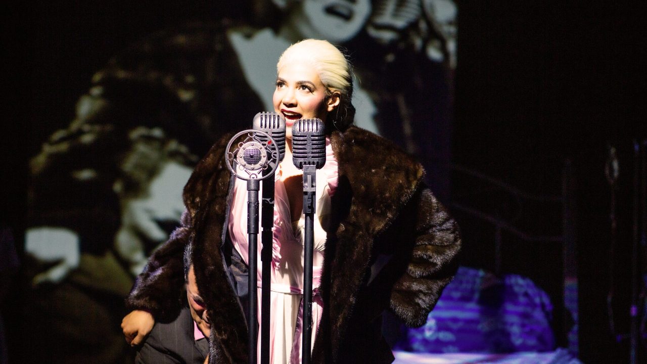 Juan Perón (Peter Gregus) embraces Eva Perón (Sophia Alawi) as she addresses the public in San Francisco Playhouse's "Evita," performing June 27 - September 7, 2024. Juan Perón (Peter Gregus) embraces Eva Perón (Sophia Alawi) as she addresses the public in San Francisco Playhouse's "Evita," performing June 27 - September 7, 2024.