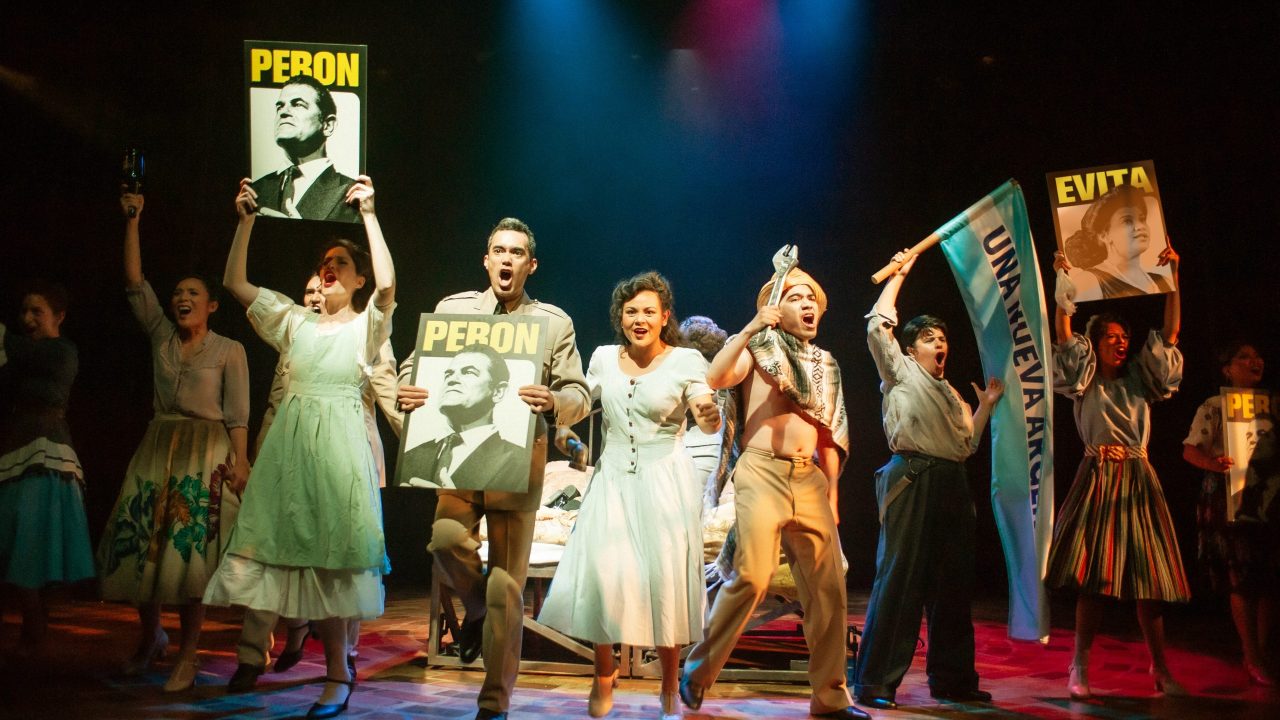 The crowd cheers for Eva & Juan Perón in San Francisco Playhouse's "Evita," performing June 27 - September 7, 2024. The crowd cheers for Eva & Juan Perón in San Francisco Playhouse's "Evita," performing June 27 - September 7, 2024.