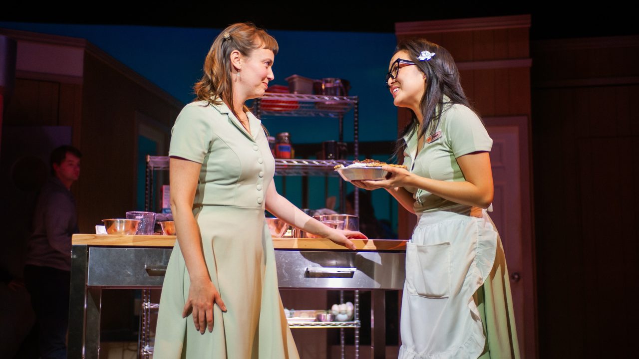 Jenna (Ruby Day) bakes a pie for Dawn's (Sharon Shao) first date in "Waitress," presented by San Francisco Playhouse November 21 – January 18. "Waitress" production photo.
