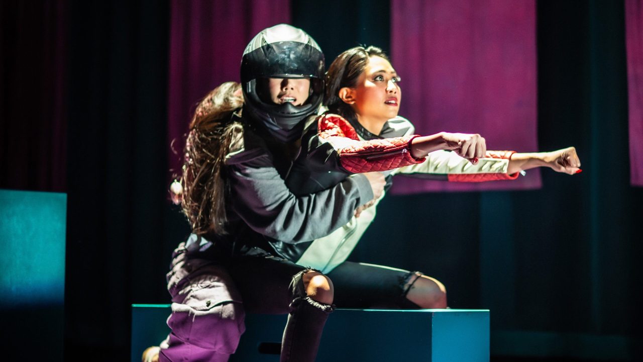 Ami (Ana Ming Bostwick-Singer) rides on a motorcycle with Exotic Deadly (Francesca Fernandez) in San Francisco Playhouse's "Exotic Deadly: Or the MSG Play," performing January 30 - March 8. Ami (Ana Ming Bostwick-Singer) rides on a motorcycle with Exotic Deadly (Francesca Fernandez) in San Francisco Playhouse's "Exotic Deadly: Or the MSG Play," performing January 30 - March 8.