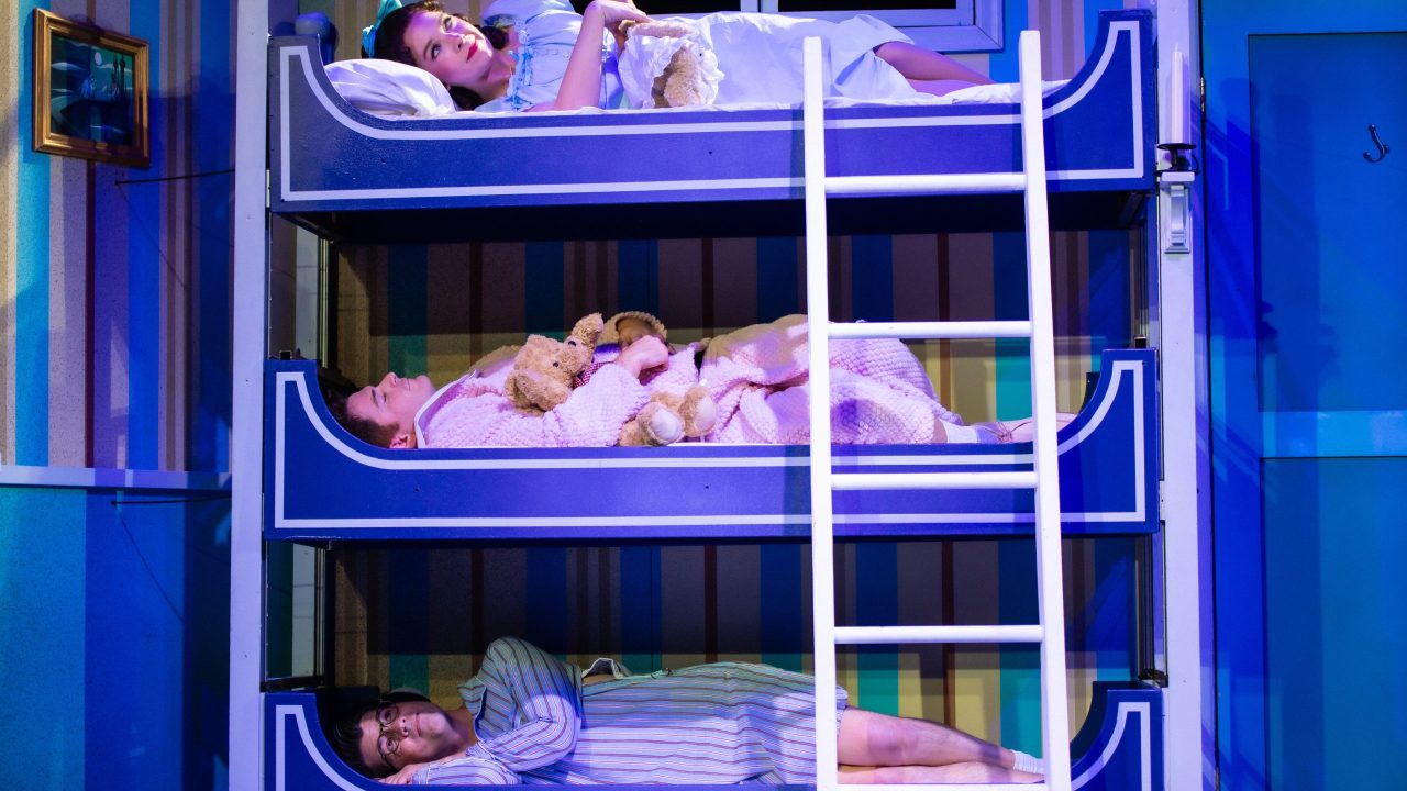 The Darling children (top to bottom: Maggie Mason, Joe Ayers, and Greg Ayers) sleep in bunk beds in San Francisco Playhouse's "Peter Pan Goes Wrong," performing September 26 - November 28.